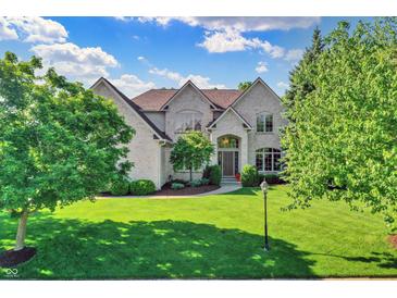 Stately two-story home with a well-manicured lawn, mature trees, and a classic brick facade at 16316 Brookhollow Dr, Westfield, IN 46074