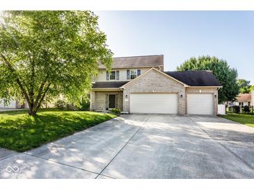 Charming two-story home featuring a three car garage, well-manicured lawn, and mature trees at 197 Ceejay Dr, Greenwood, IN 46142