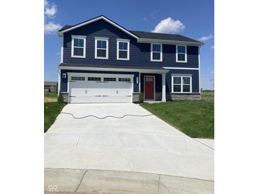 Charming two-story home with navy siding, white trim, a red door, and a spacious two-car garage at 2057 Eldin Ct, Whitestown, IN 46075