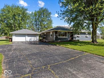Charming single-story home with a detached two-car garage, a large driveway, and a well-maintained lawn at 2233 S Miller Ave, Shelbyville, IN 46176