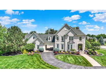 Stunning two-story brick home featuring a circular driveway, lush landscaping, and porte-cochère at 3398 Nottinghill Blvd, Plainfield, IN 46168