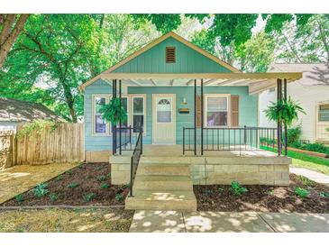Charming bungalow with covered porch, beautiful landscaping, and freshly planted flower beds at 4621 E 17Th St, Indianapolis, IN 46218