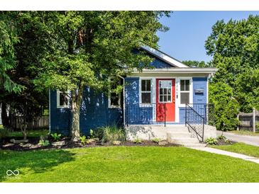 Charming blue home featuring a vibrant red front door and well-maintained landscaping at 6264 Central Ave, Indianapolis, IN 46220