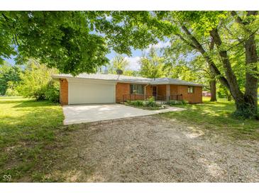 Charming brick home featuring an attached garage, front yard foliage and gravel driveway at 6498 N County Road 475 E, Pittsboro, IN 46167