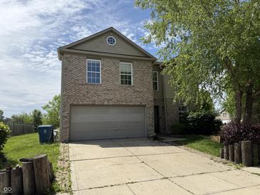 Two-story home featuring a two-car garage and well-maintained lawn with a long driveway at 10803 Gathering Dr, Indianapolis, IN 46259