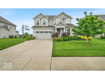 Charming two-story home features a manicured lawn, landscaped garden and an attached two car garage at 13495 Forest Glade Dr, Fishers, IN 46037