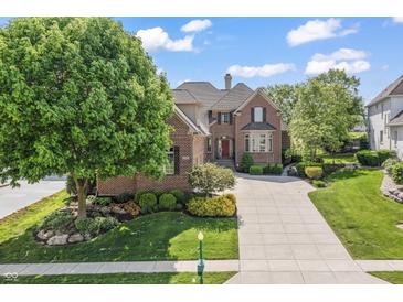 Beautiful brick home boasts mature landscaping and a spacious driveway at 16502 Grand Cypress Dr, Noblesville, IN 46060
