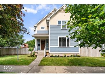 Charming two-story home featuring blue siding, complemented by a well-manicured lawn and inviting curb appeal at 2448 Broadway St, Indianapolis, IN 46205