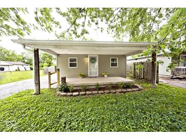 Charming home featuring a cozy covered front porch with fresh landscaping at 4910 W Caven St, Indianapolis, IN 46241