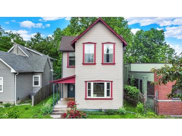 Charming two-story home with light siding, red trim, and lush landscaping in a residential neighborhood at 514 Dorman St, Indianapolis, IN 46202
