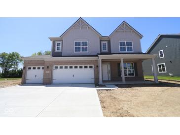 Two-story home featuring a three-car garage, gray siding, brick accents, and a covered front porch at 5517 Sienna Ct, Brownsburg, IN 46112
