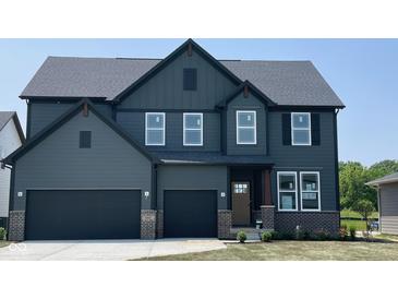 Stunning two-story home featuring a three car garage, covered porch and a dark grey exterior at 6418 Springtide Ct, Plainfield, IN 46168