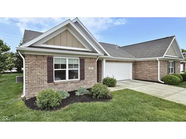 Charming brick home featuring a two-car garage, manicured lawn, and decorative window shutters at 695 Overcup St, Westfield, IN 46074