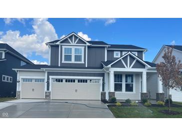Beautiful two-story home with a three car garage and a manicured lawn at 7145 Firestone Rd, Whitestown, IN 46075