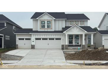 Charming two-story home boasts a three-car garage and modern farmhouse design at 7145 Firestone Rd, Whitestown, IN 46075