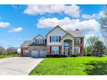 Beautiful two-story home featuring a brick facade, red shutters, and a well-manicured front lawn at 7637 Sand Run Ct, Indianapolis, IN 46259