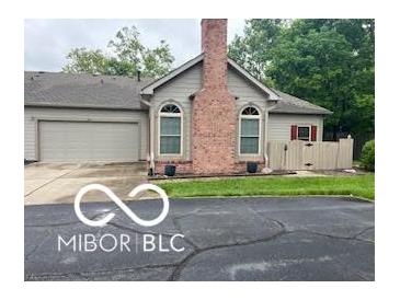 Charming home featuring a prominent brick chimney, arched windows, and attached two-car garage at 811 Gazebo Way, Greenwood, IN 46142