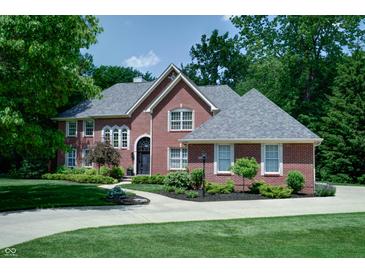 Beautiful two-story brick home featuring a well-manicured lawn, lush landscaping, and a circular driveway at 9154 Sargent Manor Ct, Indianapolis, IN 46256