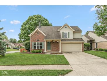 Charming two-story home with brick accents, a well-manicured lawn, and a two car garage at 11051 Oakridge Dr, Fishers, IN 46038