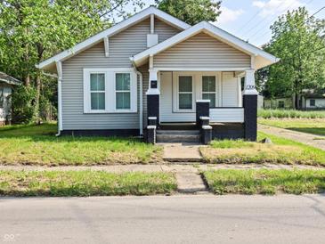 Charming home featuring a quaint front porch and neat landscaping at 1209 W 22Nd St, Anderson, IN 46016