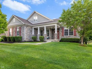 Charming stone home with red shutters and a well-manicured lawn on a sunny day at 15292 Slateford Rd, Noblesville, IN 46062
