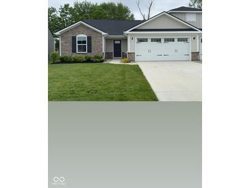 Charming home featuring a stone facade, dark shutters, and a two-car garage with lovely landscaping at 200 Mission Terrace Dr, Whiteland, IN 46184