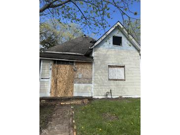 An exterior view of a distressed single-Gathering home with boarded-up windows needing full rehab at 330 N Lasalle St, Indianapolis, IN 46201