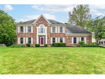 Charming brick home featuring a landscaped front yard, white shutters, and a statement purple front door at 3772 Christina Ct, Carmel, IN 46033