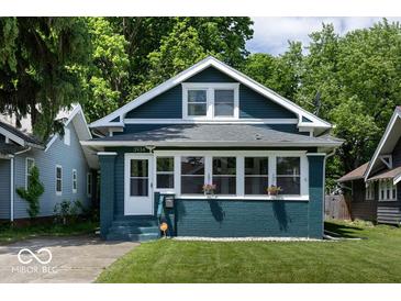 Charming two-story home featuring a blue exterior, bright windows, and a well-manicured lawn at 3934 N Kenwood Ave, Indianapolis, IN 46208