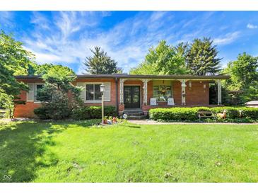 Charming brick ranch-style home with well-manicured lawn and inviting front porch at 415 Woodhill Dr, Indianapolis, IN 46227