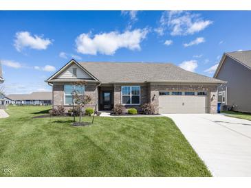Brick home featuring an attached two-car garage and a well-manicured lawn at 5196 Canberra Ct, McCordsville, IN 46055