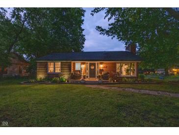 Charming brick home with a well-maintained lawn and cozy front porch seating area at 5601 Rosslyn Ave, Indianapolis, IN 46220