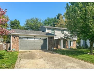 Charming two-story home with well-maintained lawn, brick accents and a gray garage door at 713 Colonial Way, Greenwood, IN 46142