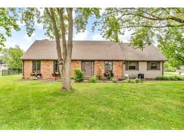 Charming brick home features a well-manicured lawn, flower boxes, and a classic front door at 7633 Janean Dr, Brownsburg, IN 46112