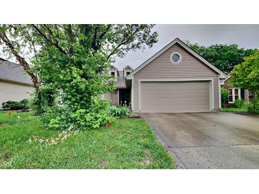 Charming single-Gathering home features a tan exterior, two-car garage, and mature trees at 7859 Chesapeake E Dr, Indianapolis, IN 46236