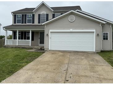 Charming two-story home with a white garage door, and a cozy front porch at 8939 Newchurch Blvd, Indianapolis, IN 46231