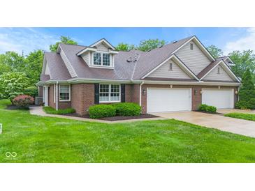 Charming brick home featuring a three-car garage and well-manicured landscaping at 11510 Monon Farms Ln, Carmel, IN 46032