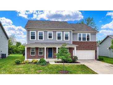 Charming two-story home featuring gray siding, brick accents, a well-manicured lawn, and an attached two-car garage at 1384 Horse Shoe, Greenwood, IN 46143