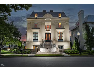 Elegant stone home with meticulous landscaping and a grand entrance at twilight at 1894 Rhettsbury St, Carmel, IN 46032