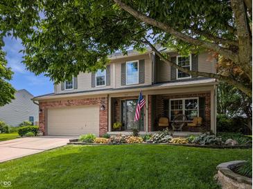 Charming two-story home featuring a well-manicured lawn, front porch and attached two car garage at 319 Mcintosh Ln, Westfield, IN 46074