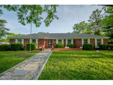 Charming brick home with manicured front yard and unique stone walkway leading to the front door at 3457 W 58Th St, Indianapolis, IN 46228