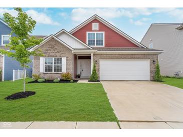 Charming two-story home featuring a brick facade, two-car garage and well-manicured lawn at 5304 Maywood Dr, Whitestown, IN 46075