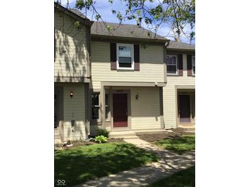 Inviting townhouse featuring neutral siding, dark shutters, and well-maintained landscaping at 6070 Southbay Dr, Indianapolis, IN 46250