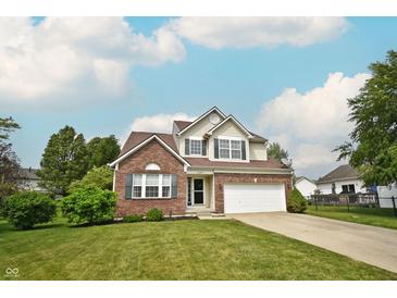 Charming two-story home featuring a brick facade, attached two-car garage, and a well-maintained lawn at 6549 Wilshire Pl, Zionsville, IN 46077