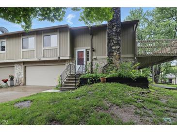 Charming split-level home with a stone chimney and inviting front entrance at 7940 Sunfield Ct, Indianapolis, IN 46214