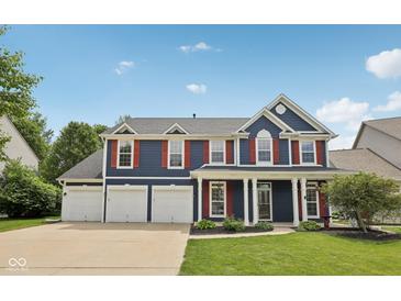 Charming two-story home boasts a three-car garage, well-manicured lawn, and classic curb appeal at 8241 Holmard Pl, Indianapolis, IN 46259