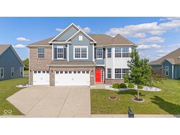 Charming two-story home with a well-manicured lawn, attached garage, and red front door at 9917 Gallop Ln, Fishers, IN 46040