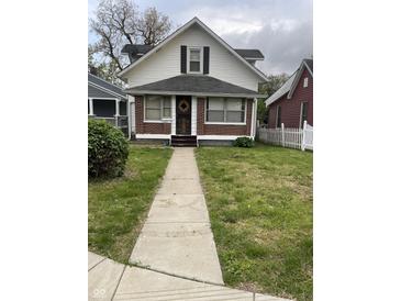 Charming two-story home with a brick foundation, front yard, and sidewalk leading to the front door at 1021 W 37Th St, Indianapolis, IN 46208