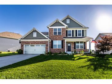 Charming two-story brick home with a well-manicured lawn and attached two-car garage, perfect for Gathering living at 1065 Park Ct, Avon, IN 46123
