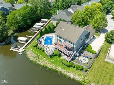 Stunning aerial view of the property showcasing a private pool, boat docks and waterfront access on a sunny day at 11061 Mast Ct, Fishers, IN 46040